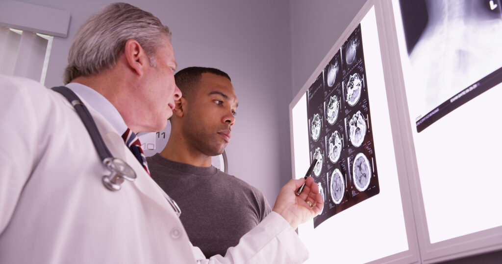 Mid aged medical doctor reviewing x ray of african patient