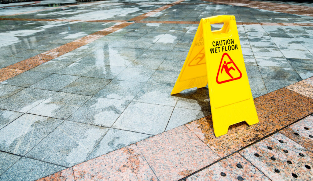 Yellow wet floor warning sign on the floor.