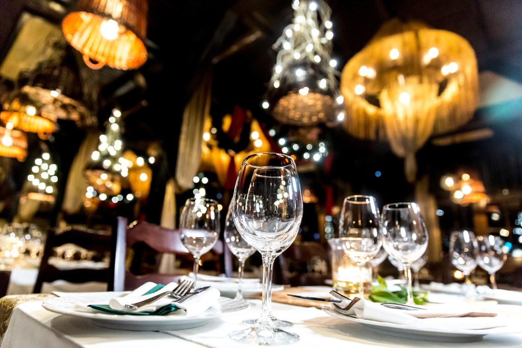 Elegant restaurant table setting with wine glasses, representing Knowles Law Firm's sponsorship of the Christ the King SPICE Fundraiser