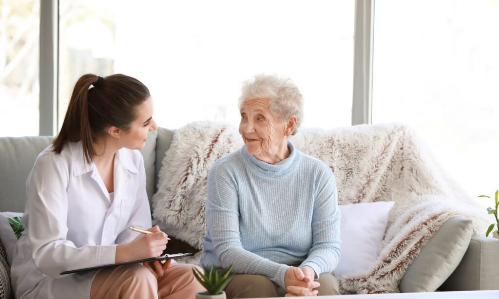 Doctor taking notes while speaking with a senior woman in a nursing home